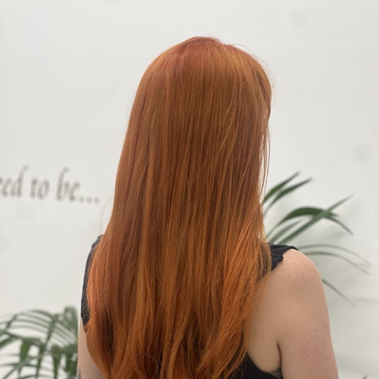Long hair coloured a vivid copper red