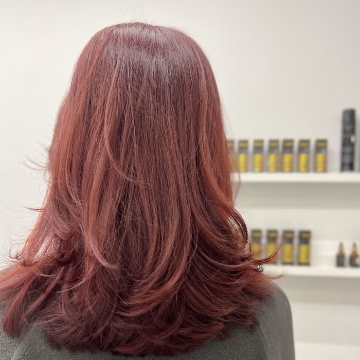 A red-pink shade on shoulder-length hair