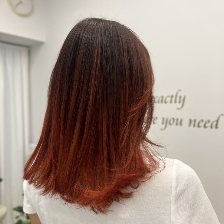 Copper red shoulder-length hair with darker roots