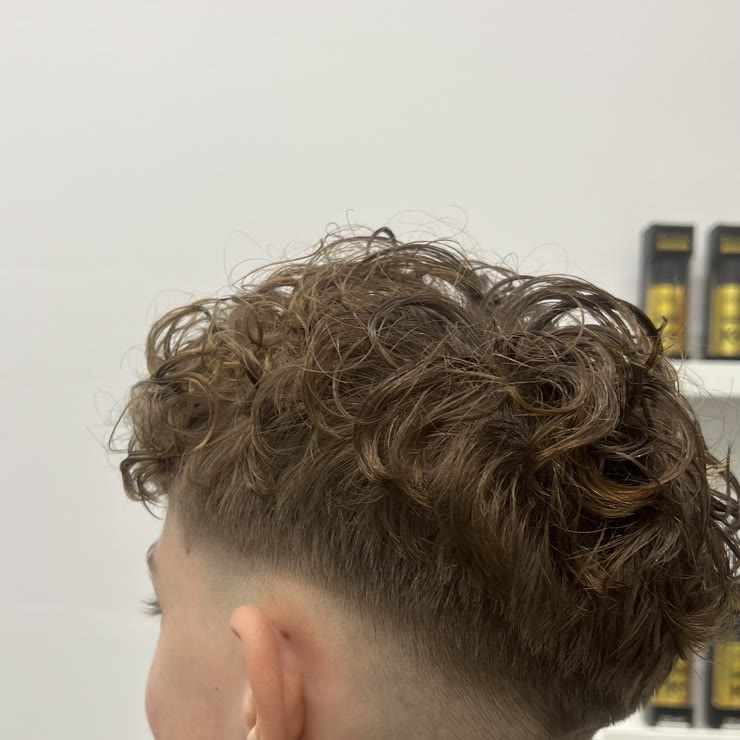 Curls from a perm above closely cut sides