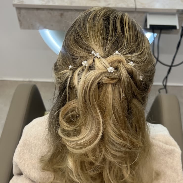 A half-up style with small pearls and curls, done in the salon